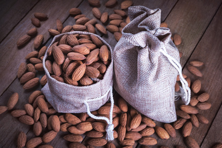 A lot of almonds falling from inside the fabric bag.の写真素材