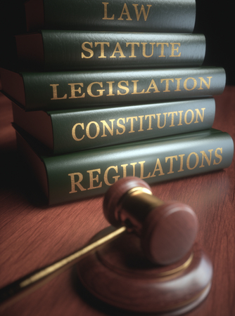 Wooden hammer with gold details and books in the background.の写真素材