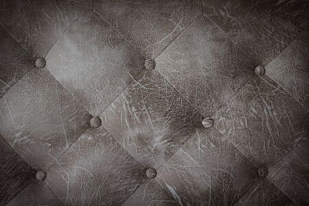 Closeup dark brown leather sofa upholstery with buttons texture background.の写真素材