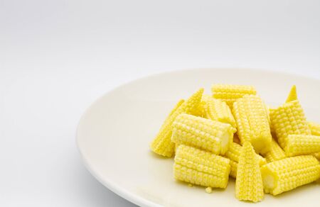 Heap cut baby corn in dish on white background.の写真素材