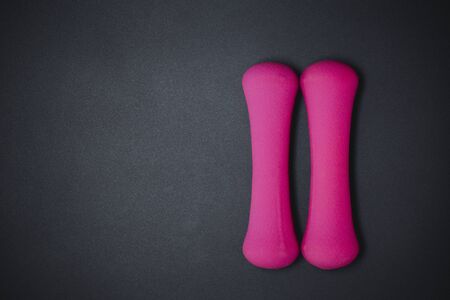 Pink dumbbells on black background, sport and fitness concept.の写真素材