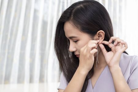 Women wearing earrings while dressing up for work.の写真素材