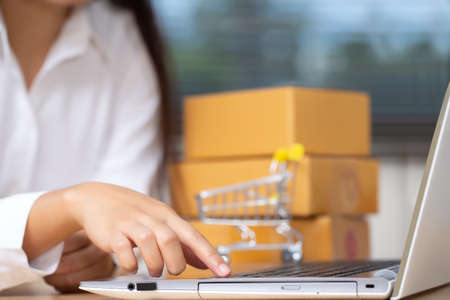 Female seller hand is pressing enter to accept an online purchase of a customer who makes an order in her small business. Online Shopping and e-commerce concept.の写真素材