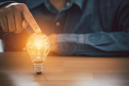 Human hand touch light bulb. Business, Innovation and creative design concept.