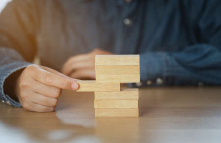 Human hand choosing a wooden block in the middle represents a different idea. Business leadership for winning leadership teams, successful people and influential leaders concept.の写真素材