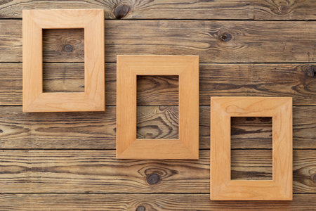 Three wooden frame or photo frame over wooden background, copy space, design and home interior.の写真素材