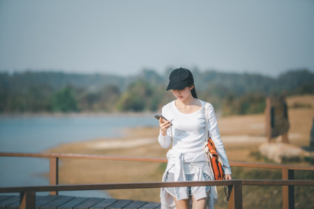 Asian woman traveler uses a smartphone to view her travel plans. over nature background.の写真素材