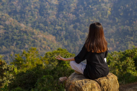 Woman meditating yoga at mountains, practices meditation, serenity, Lifestyle relaxation, Emotional, Outdoor harmony with nature.の写真素材