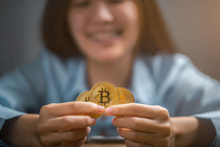 Bitcoins, Bitcoin in hand of woman, Digital cryptocurrency Online, virtual future currency concept.の写真素材