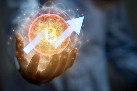 Businessman invests in bitcoin. Businessman holding golden virtual bitcoin. Cryptocurrency investment concept.の写真素材