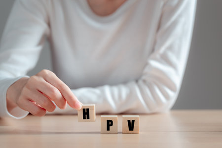 HPV (Human Papillomavirus) acronym on wood block, Asian woman  holding wooden block, viruses Some strains infect genitals and can cause cervical cancer. Women health concept.の写真素材