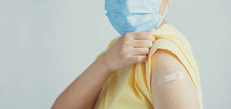 Human wearing face mask and showing his vaccinated arm. vaccination, recommended inoculation...