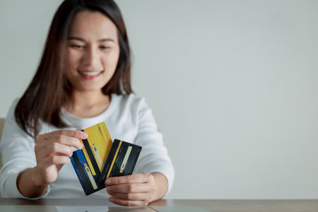 Woman holding and choosing credit card to use, Online payment concept.