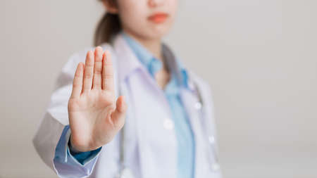 Asian famale doctor give you reject gesture, gesturing STOP coronavirus COVID-19 disease global pandemic outbreak.の写真素材