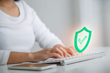 Businesswoman working on working on wireless keyboard, select icon security in personal data...