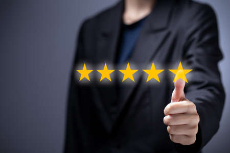 Woman hand with thumb up to five-star on modern virtual screen, showing satisfaction excellence...