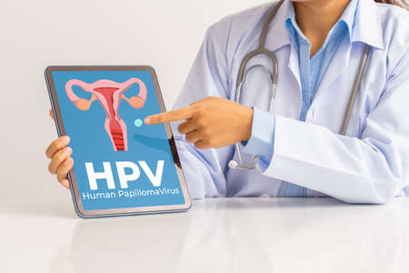 HPV (Human Papillomavirus) Female doctor explaining knowledge and pointed out women health problems on tablet screen, viruses Some strains infect genitals and can cause cervical cancer.の写真素材