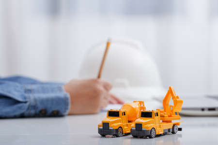 Concrete mixer truck and excavator on architect's desk, Engineering objects, Construction site.の写真素材