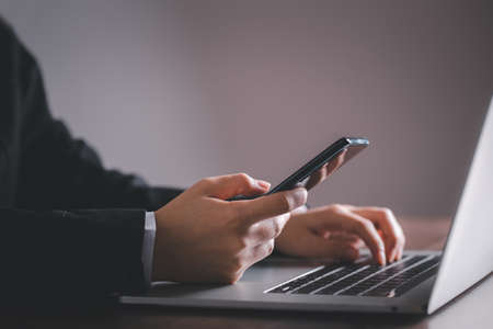 Business man using smart phone with laptop and copy space.の写真素材