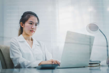 Business woman sitting and using laptop in office.の写真素材