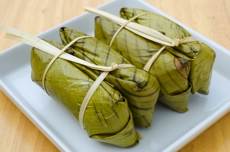 KHAO TOM MAD, Thai traditional dessert, steamed sticky rice in banana leaf packagingの写真素材
