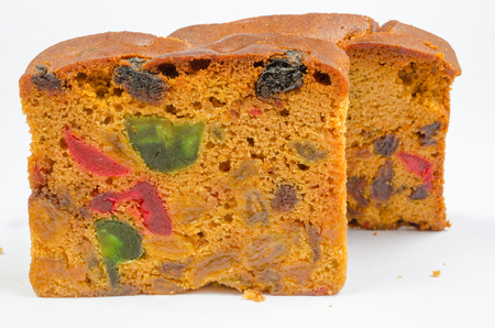 delicious sliced fruit cake with mixed fruit and cherries on white backgroundの写真素材