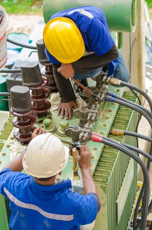 Nonthaburi, Thailand - September 28, 2015 : Electrician preparing an oil change a power transformer of condominium. This activity is according to the specified period.のeditorial素材