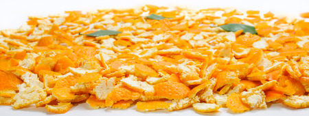 Layer of many various mandarin skins and leaves on flat surfaceの写真素材