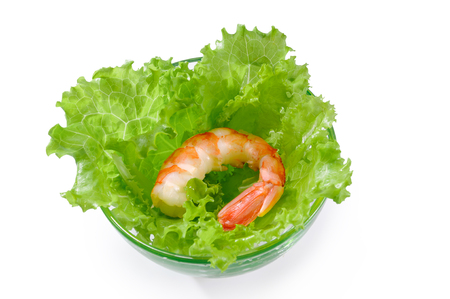 One big cooked peeled shrimp on lettuce leaves in glass bowl isolated on white backgroundの写真素材