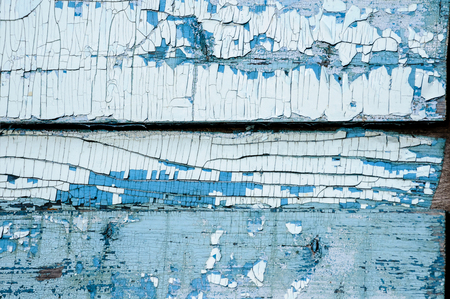 Texture of very old badly scratched wooden planks with badly cracked and peeling blue and white paintの写真素材