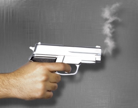 Hand shooting gun and smoke on white backgroundの写真素材