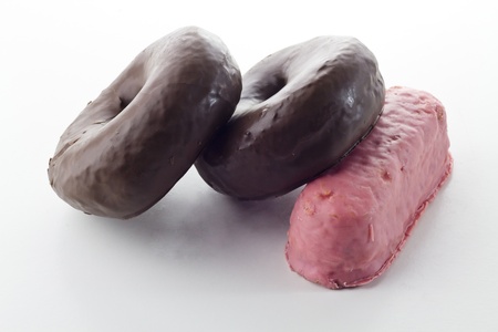 pink cake and chocolate donuts isolated on white backgroundの写真素材