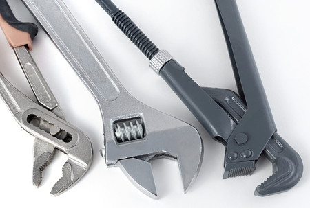 Horizontal image of three different metal spanner wrench and for works for gas pipes and plumbing works close-up, on white background.の写真素材
