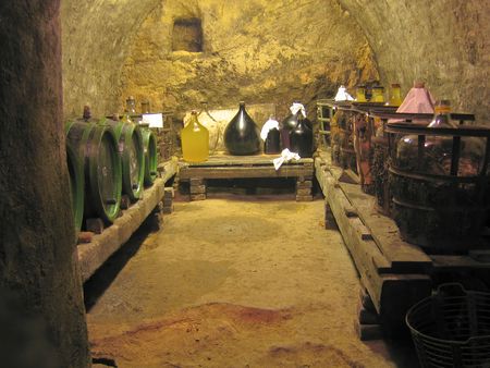 old wine cellar with oak barrels and glass containers