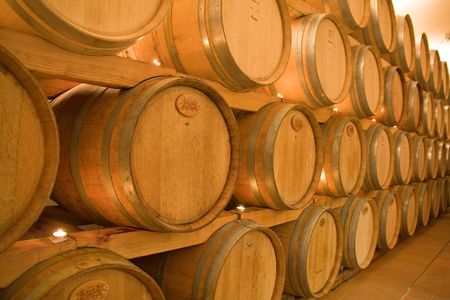 stacked win barrels in the wine cellar