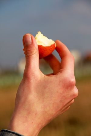 young female hand holding red bitten appleの写真素材