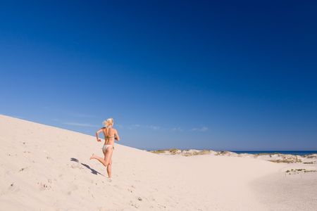 beautiful female exercising on the sand dunesの写真素材
