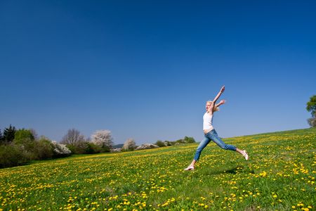 young female having fun on flowery meadowの写真素材