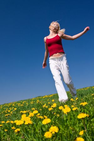 young woman having fun on a flowery meadowの写真素材