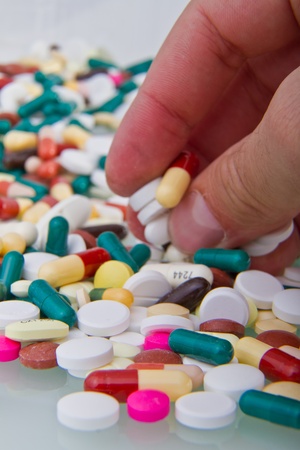 hand grabbing pile of pillsの写真素材