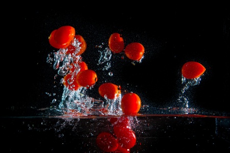 tomatoes splashing in the waterの写真素材