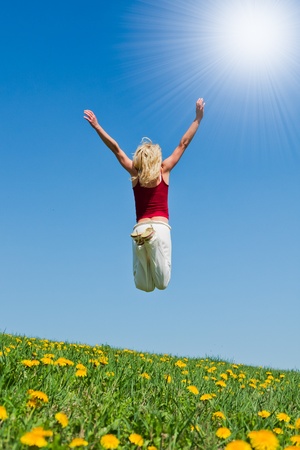 young woman having fun on a flowery meadowの写真素材