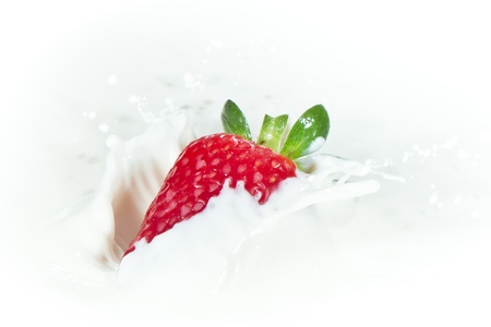 delicious fresh strawberry falling into splashing milkの写真素材