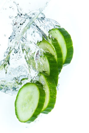 sliced cucumber splashing water isolated on white backgroundの写真素材