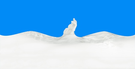 splashing milk isolated on blue backgroundの写真素材