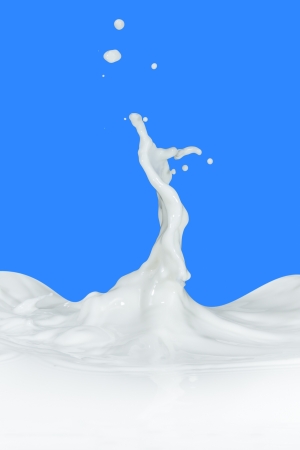 splashing milk isolated on blue backgroundの写真素材