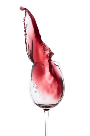 red wine splashing out of a glass, isolated on whiteの写真素材
