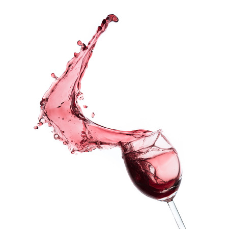 red wine splashing out of a glass, isolated on whiteの写真素材