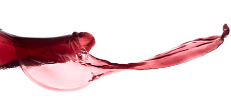 red wine splashing out of a glass, isolated on whiteの写真素材