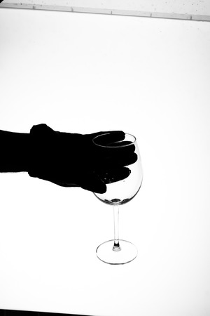 red wine splashing out of a glass, isolated on whiteの写真素材